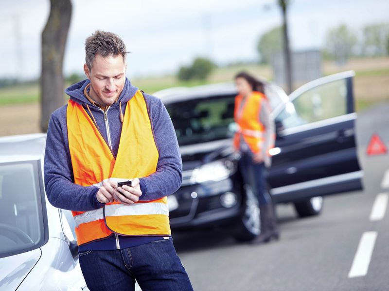 A man wearing a high vis waistcoat on his phone