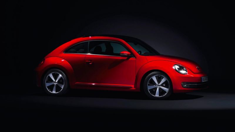 Une Beetle Rouge de profil dans un environnement sombre.
