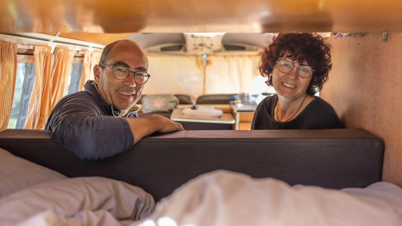 Ein Paar sitzt in einem VW Bus T1.