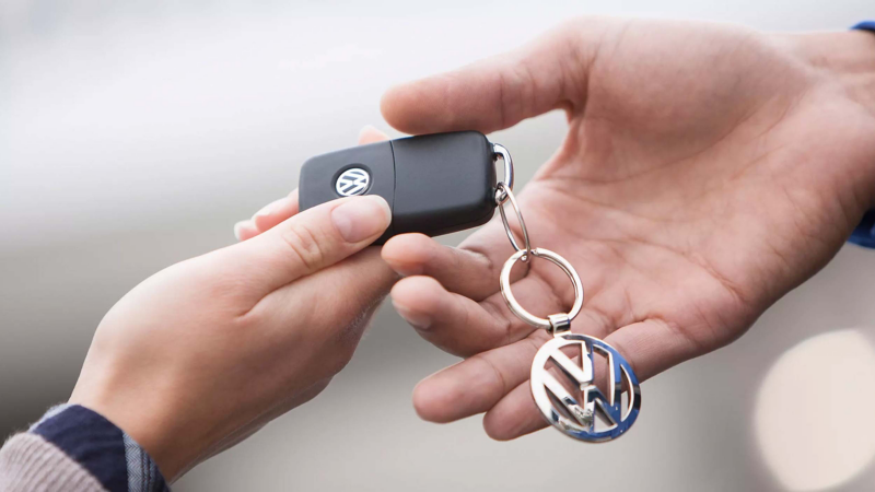 a close up of hands exchanging a VW Van key