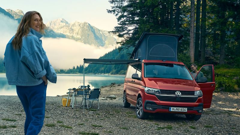 Une VW California 6.1 est garée au bord d’un lac.