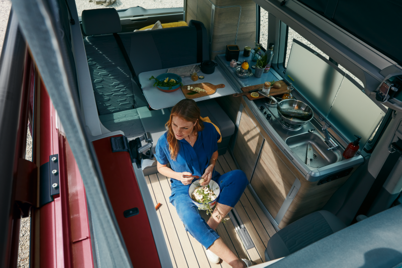 Mujer comiendo en una Volkswagen California