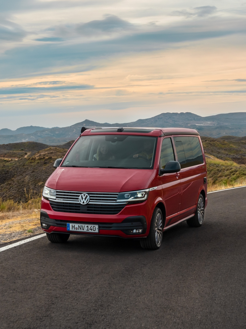 Ein VW California fährt über eine Landstraße.