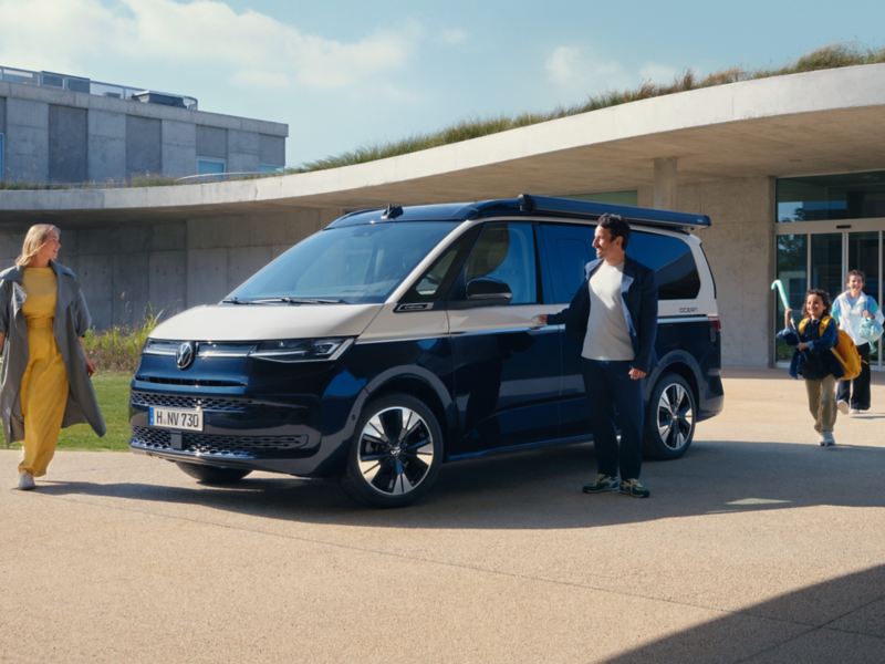 Eine Familie neben einem VW California.