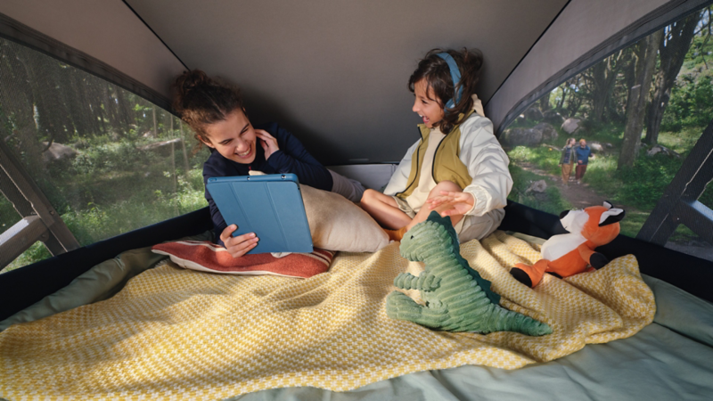 Two children play happily in the pop-up roof of the California.