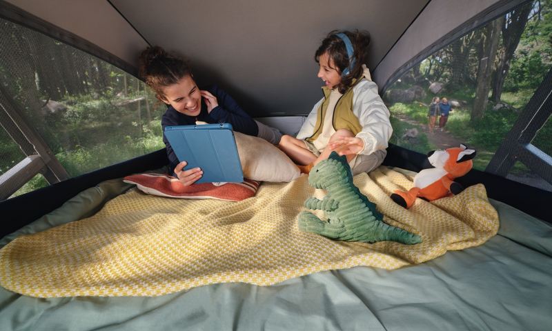 Zwei Kinder sitzen im Hochstelldach vom VW California.