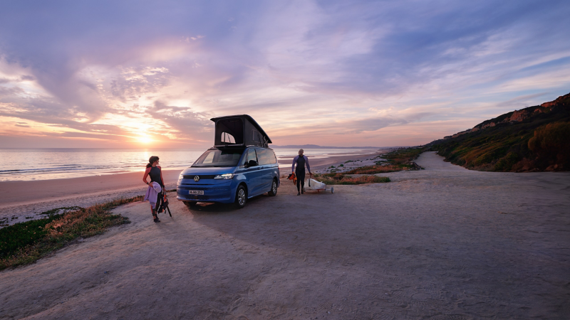 The VW California is parked on the beach.