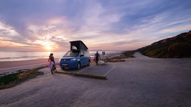 Le Volkswagen California sur une plage avec des surfeurs.