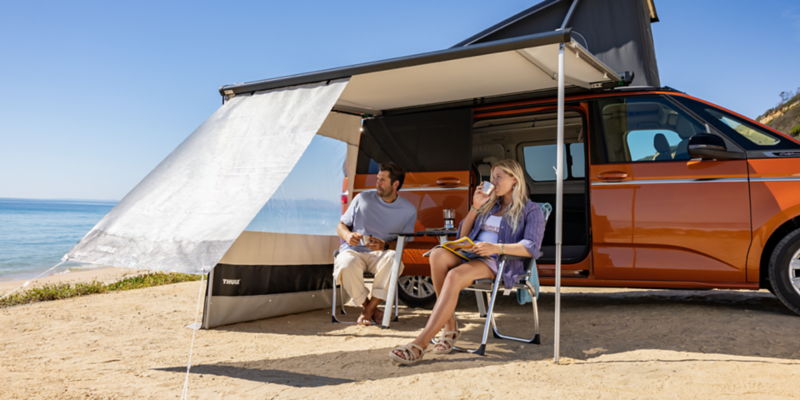 VW California z wysuniętą markizą na plaży.