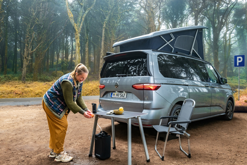 rincer un fruit sur la table pour un repas devant le van camping-car california vw volkswagen