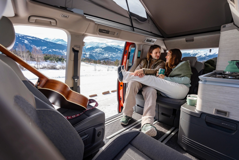 El VW Nuevo California aparcado en la orilla junto a dos personas.