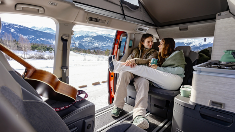 Un couple assis dans un van VW California.