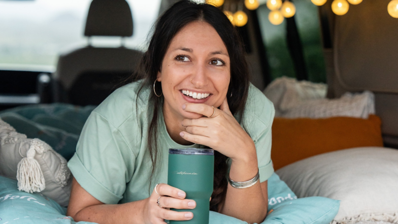 Eine Frau liegt in einem California mit einer Tasse in der Hand