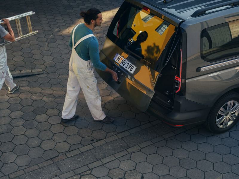 Man laadt iets in de koffer van een Volkswagen Caddy Cargo Dubbele cabine