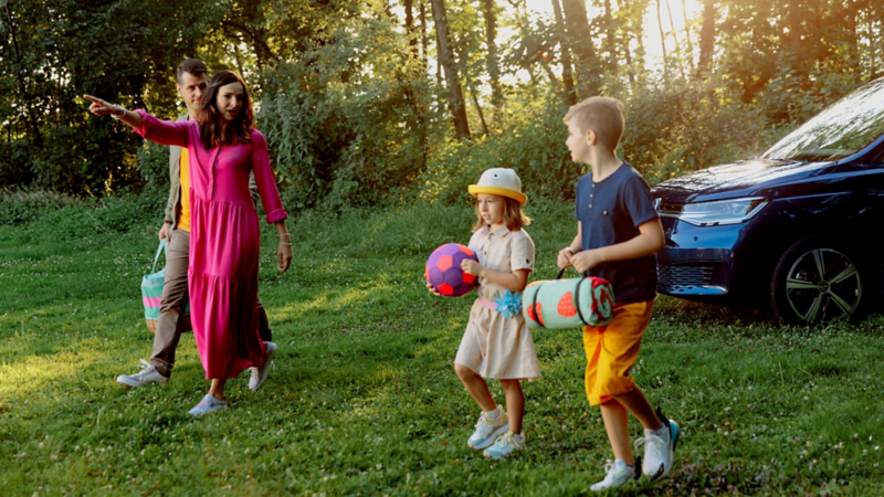 Une famille marche devant le Caddy