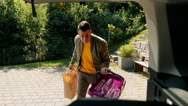 EIn Mann belädt den Kofferraum vom Caddy