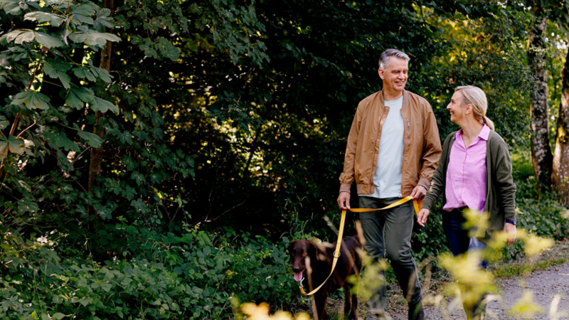 Ein Paar spazieren mit ihrem Hund in der Natur