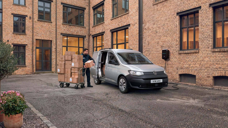 a man loading boxes into the caddy cargo side door