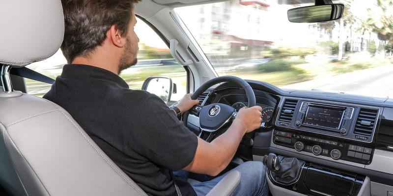 En mand kører i en Volkswagen California.