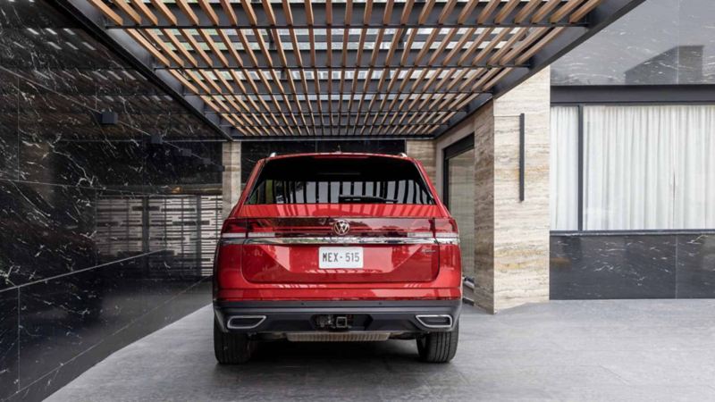 Camioneta SUV de Volkswagen en color rojo estacionada en una cochera de casa moderna.