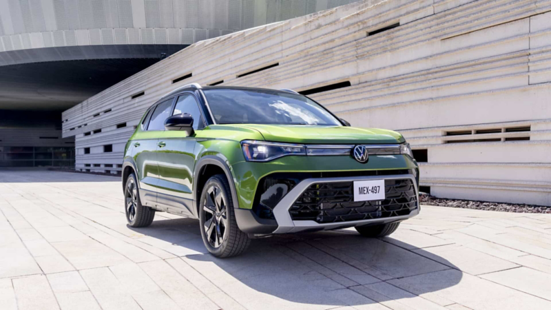 Volkswagen Taos 2025 de color verde a las afueras de un edificio moderno de concreto.