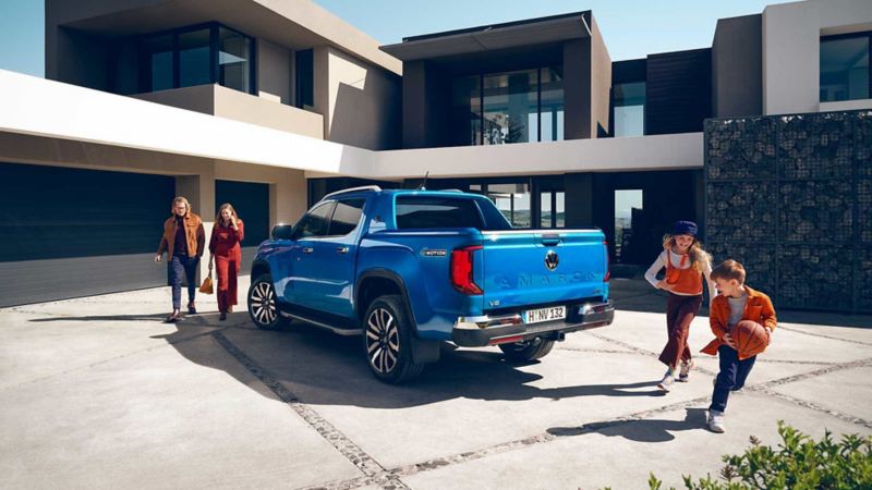 Pick up 2023 Amarok de Volkswagen en color azul, estacionado a las afueras de casa moderna.