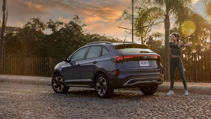 Mujer hace ejercicios de calentamiento detrás de una camioneta Nivus de Volkswagen. 