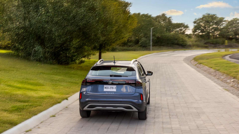 Vista trasera de Volkswagen Nivus azul en camino adoquinado
