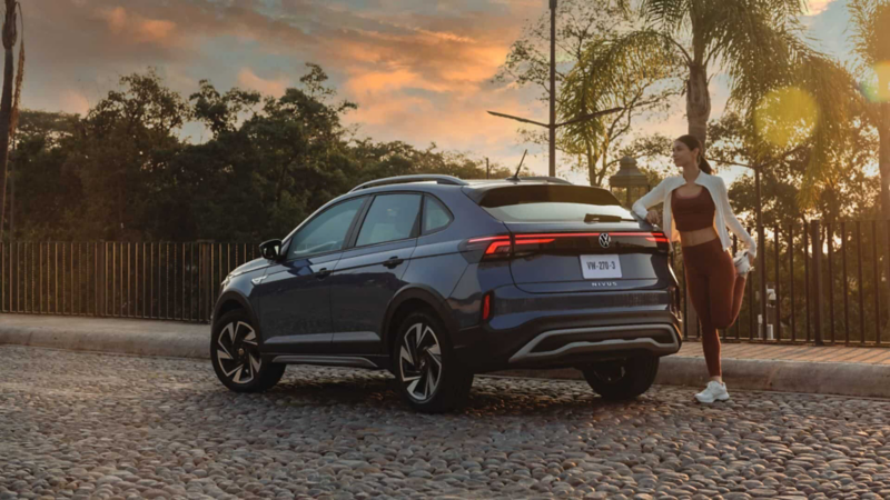 Mujer estira pierna junto a cajuela de nuevo Nivus 2026.