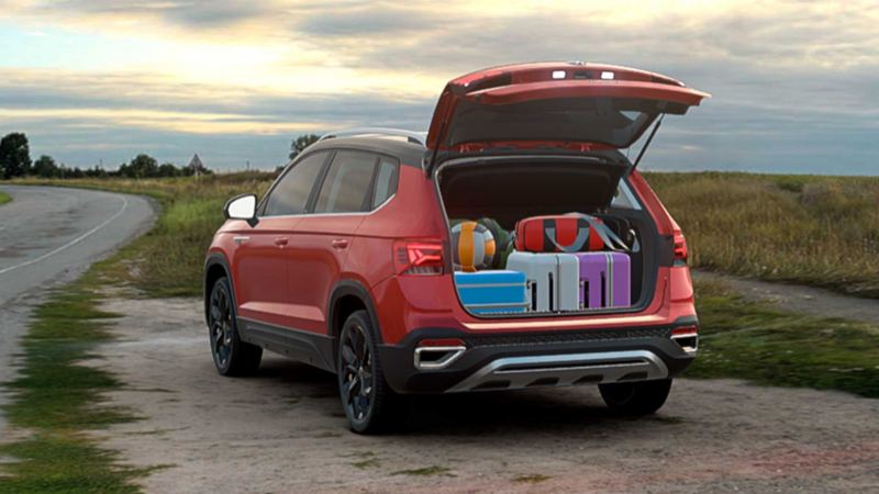 Camioneta 2022 - Taos de Volkswagen en color rojo con cajuela trasera abierta que muestra maletas. 