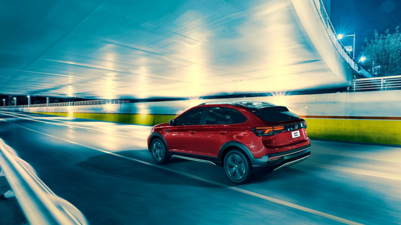 VW Nivus en color rojo atraviesa tunel dentro de autopista. 