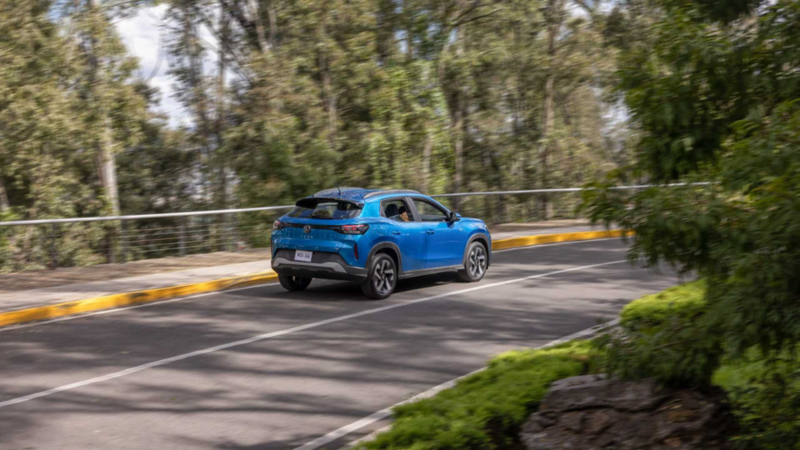 Volkswagen Tera. Vista trasera de SUV de color azul en movimiento sobre carretera rodeada de árboles.