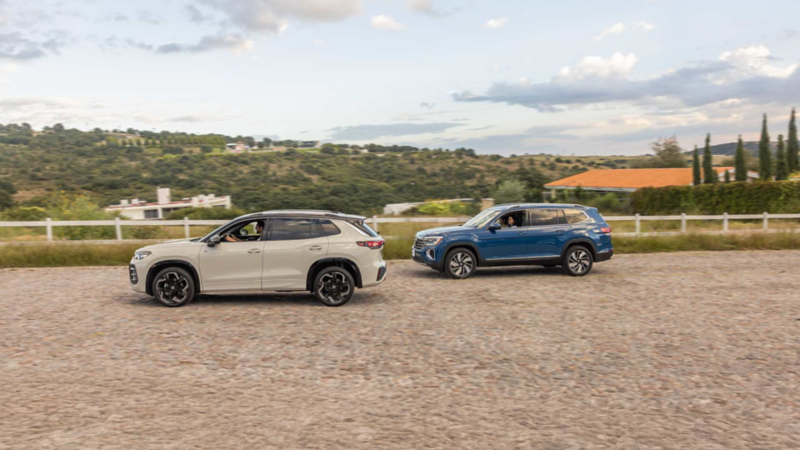SUV Volkswagen Tiguan y Teramont de color azul en carretera de un pueblo.