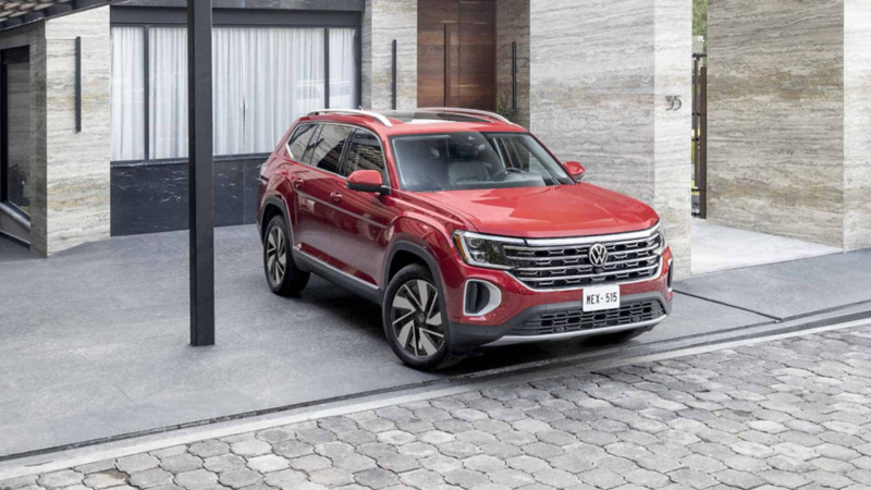 Camioneta de lujo Teramont 2024 en color rojo estacionado afuera de edificio exclusivo.
