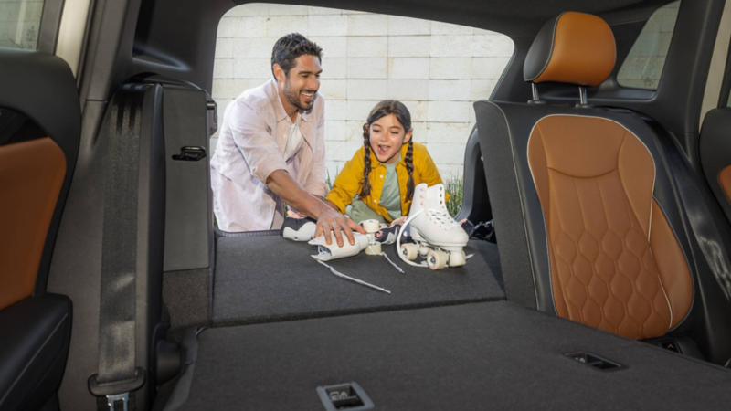 Padre e hija guardan patines en cajuela de Volkswagen Taos.