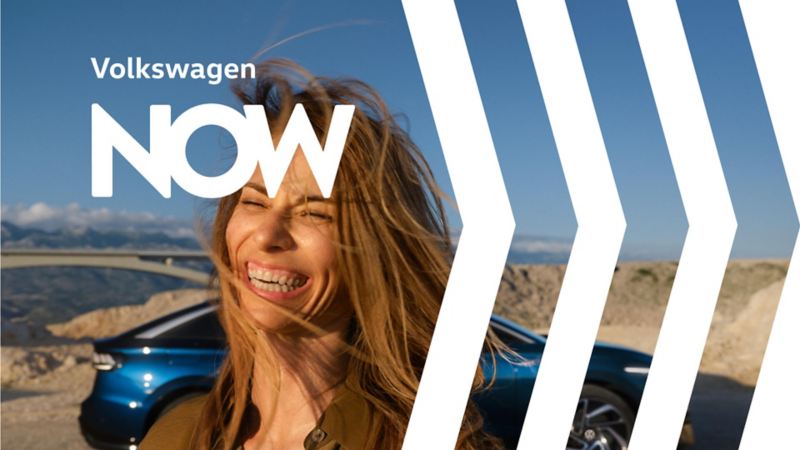 Una chica sonriendo frente a un Volkswagen ID.4 en la montaña de la campaña NOW
