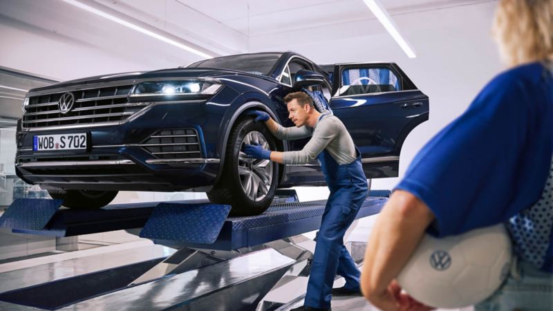 Especialista Volkswagen revisa la rueda de un VW en un taller