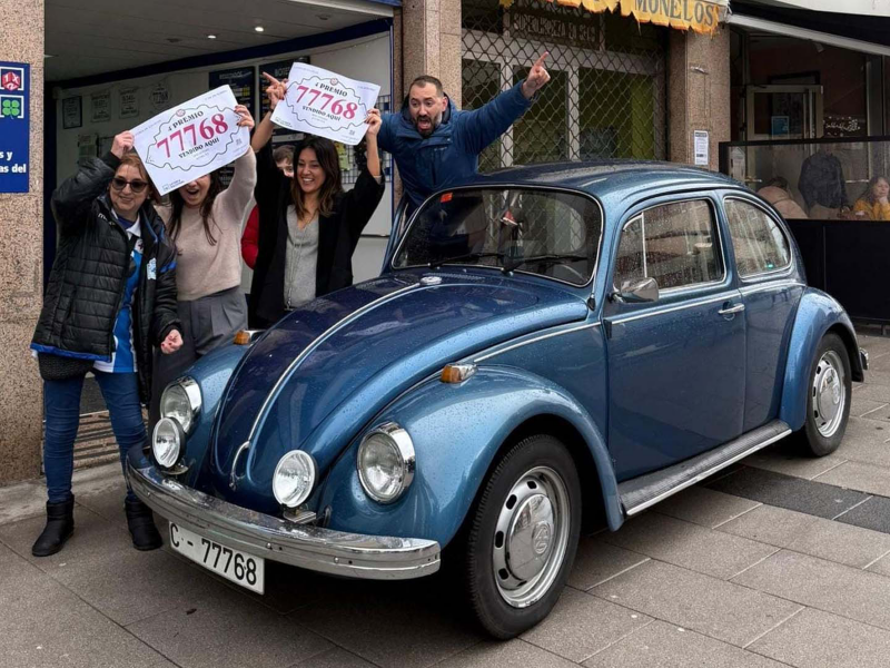 Un grupo con el numero ganador de la lotería junto a un Volkswagen Beetle con la misma matrícula