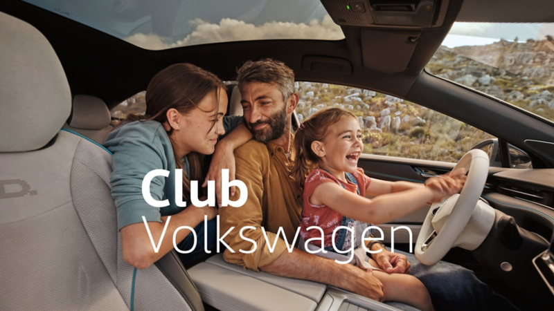 Una familia con un padre en el interior de un Volkswagen con el logo de Club Volkswagen