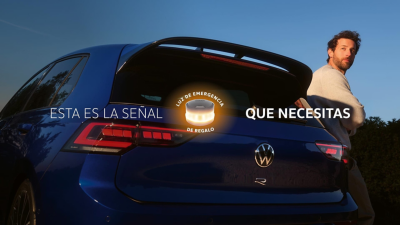 Un chico apoyado en un Volkswagen Golf R y la baliza de la DGT sobreimpresa