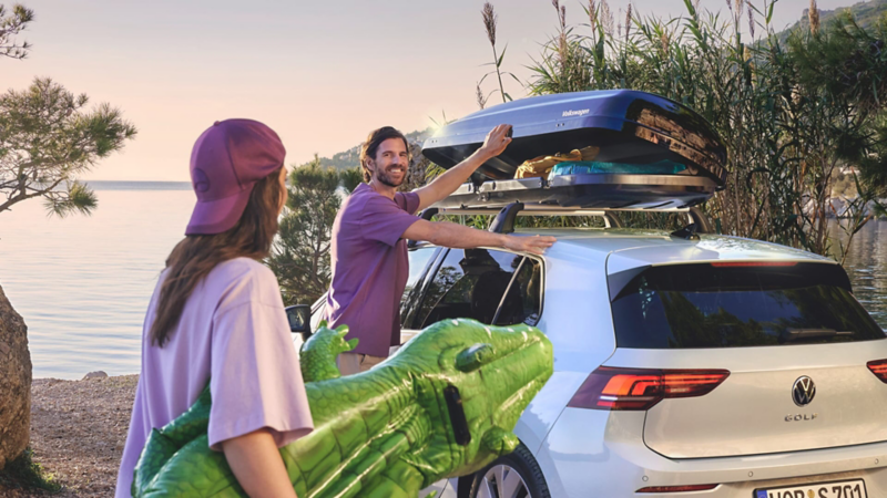 Una pareja al lado de un Volkswagen Golf