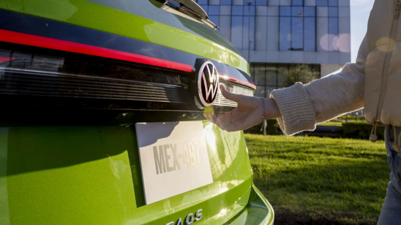 Mujer abre cajuela de Nuevo Taos 2025, en color exterior verde. 