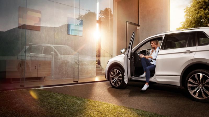 Women sitting in the VW Tiguan with her smartphone