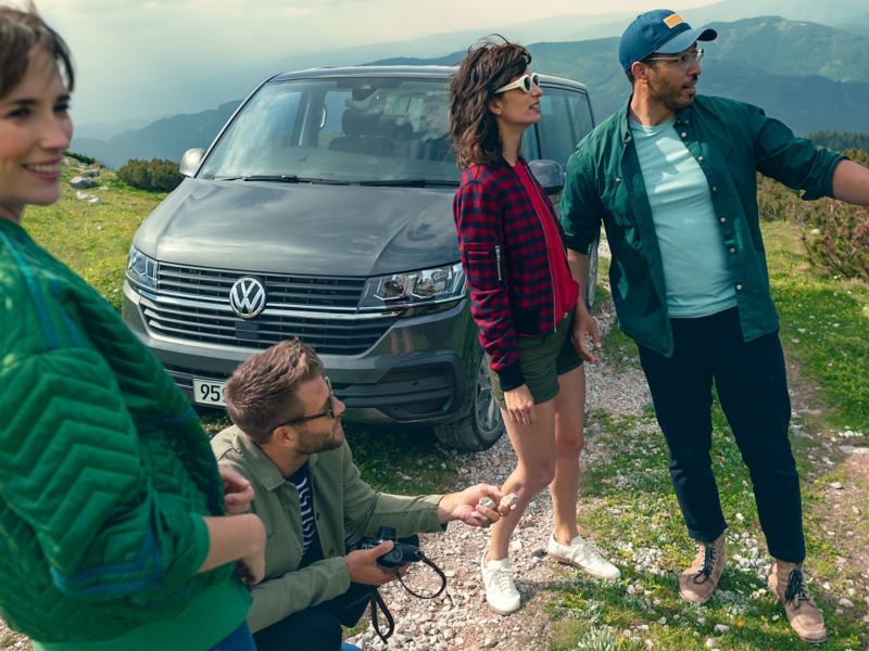 Volkswagen Caravelle van parked on the hill top with people around
