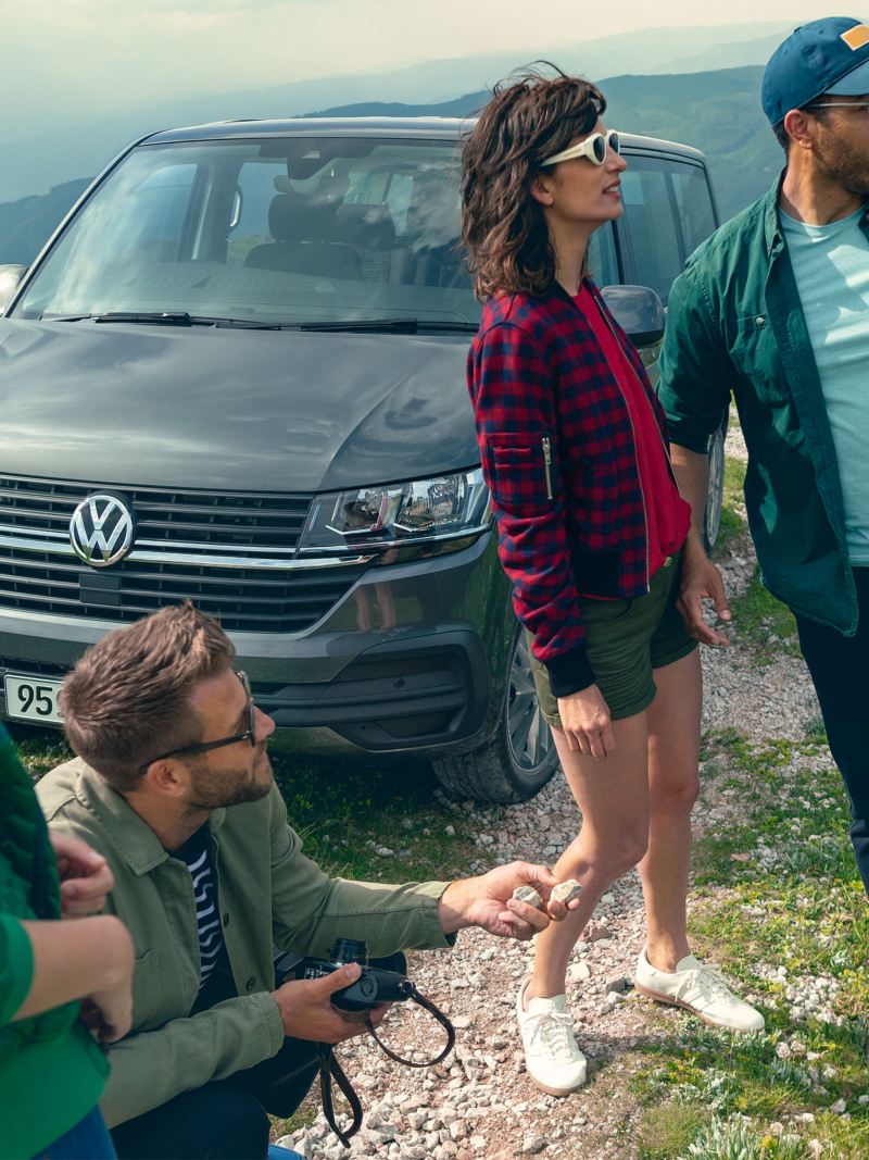 Volkswagen Caravelle van parked on the hill top with people around.