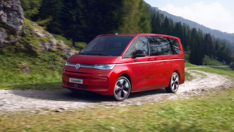 A woman opens the driver door of the VW Multivan.