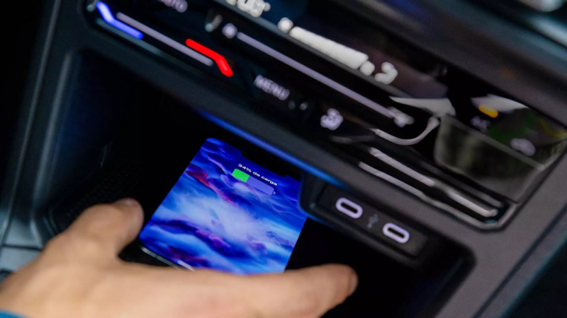 Cargador inalámbrico de Volkswagen carga batería de celular en consola central. 