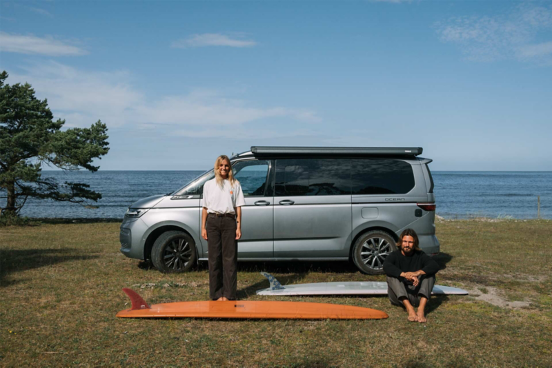 Caroline och Sebastian med surfbrädor framför VW California på Gotland.