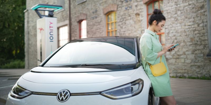 Une femme vérifie le processus de recharge de son modèle VW ID. grâce à l’application We Charge