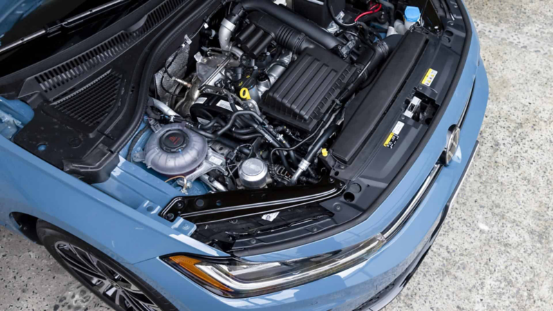 Cofre de Volkswagen abierto con motor que muestra cilindros y cubiertas plásticas.